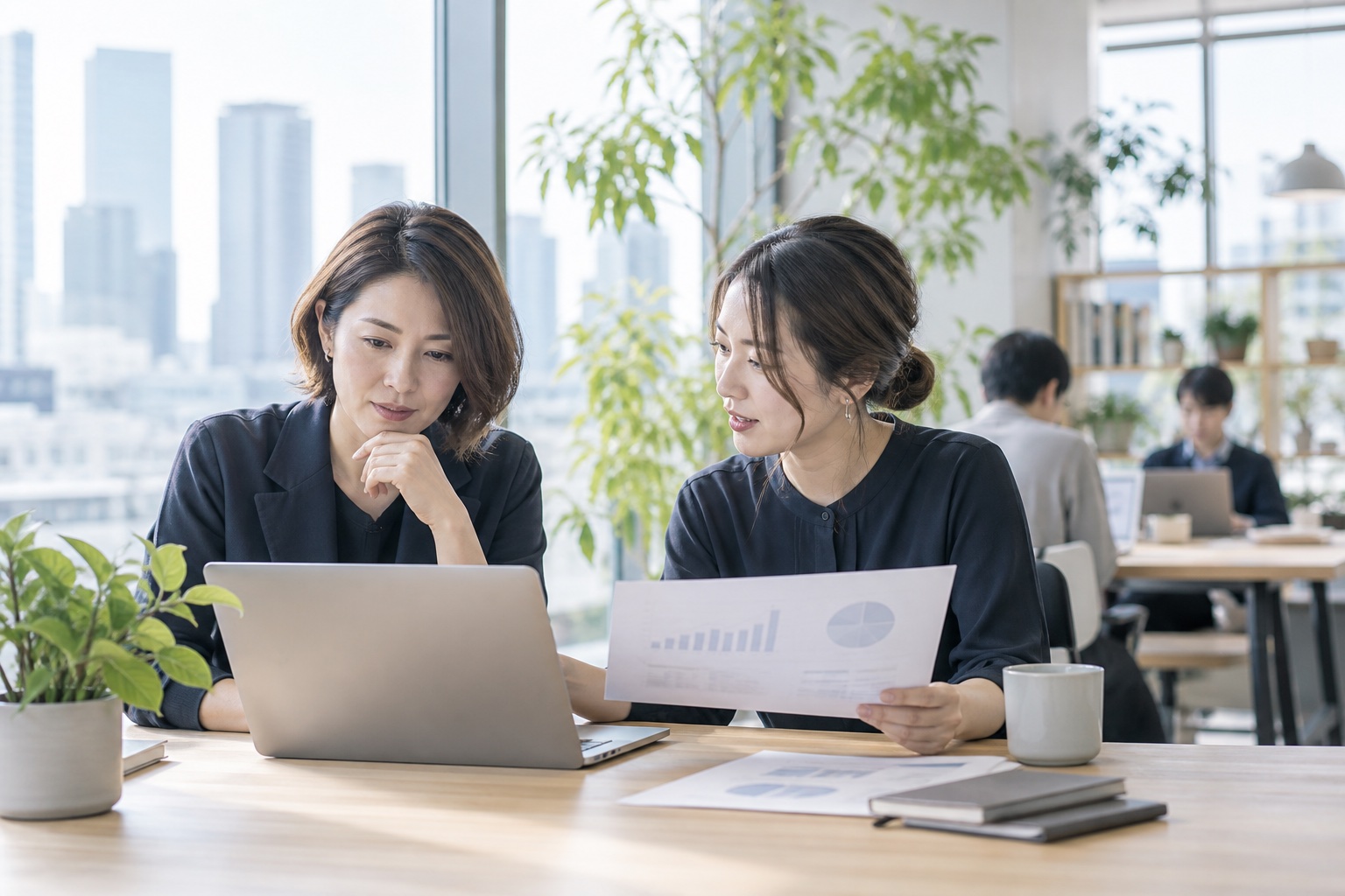 オフィスで事業の資料を確認する、架空のスタートアップ経営者と同僚